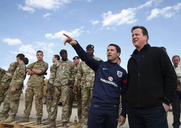 David Cameron with footballer Michael Owen as they visit British soldiers at Camp Bastion