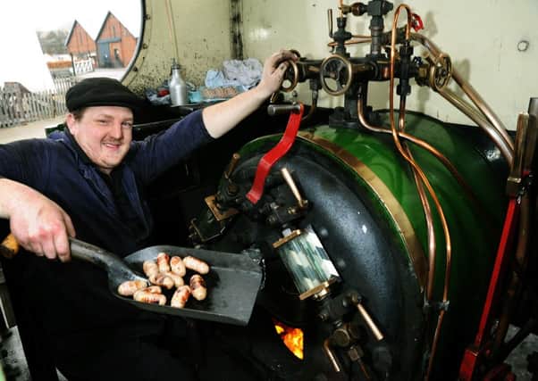 Matt Ellis, a rail co-ordinator  at the National Railway Museum cooking sausages in the firebox of 'Teddy', a tank locomotive that pulls the Santa special trains at the museum.