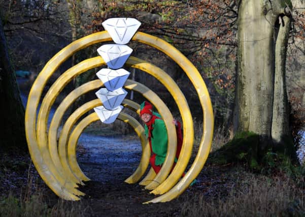 Moira Smith, visitor services manager at the Bolton Abbey Estate, dressed as an Elf looking through the Five Gold Rings