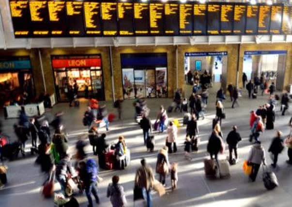 Travellers wait for their trains as the Christmas rush starts