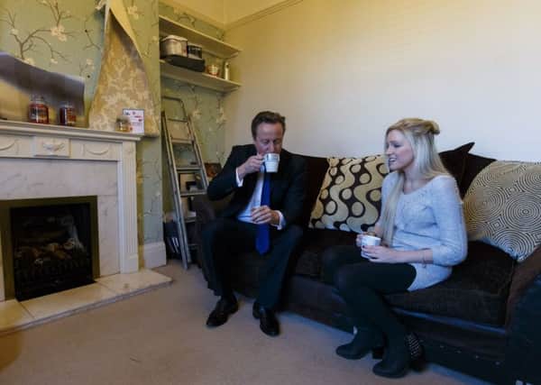 David Cameron has a cup of tea with Sharon Ray during a visit to her home in Southampton