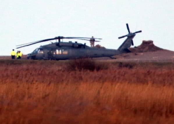 A US military helicopter that has landed near the scene at Salthouse in  Norfolk following a crash near Cley-next-the-Sea.