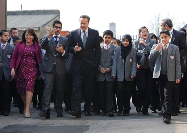 David Cameron meets head teacher Sajid Raza and children from Kings Science Academy, Bradford on a visit in 2012.
