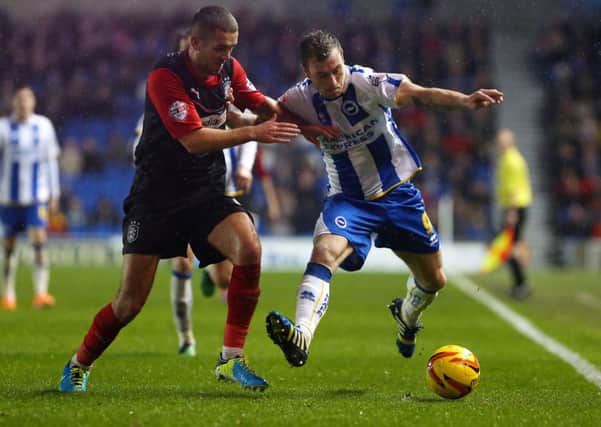 Leeds United and Burnley are chasing Brighton's Ashley Barnes, who is pictured, right, playing against Huddersfield.