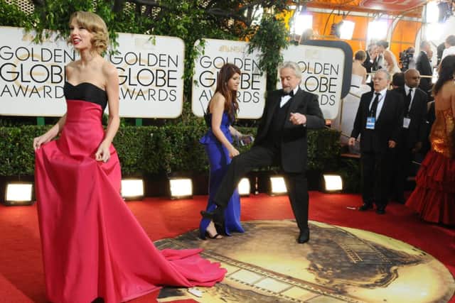 Taylor Swift, left, and Michael Douglas arrive at the 71st annual Golden Globe Awards at the Beverly Hilton Hotel