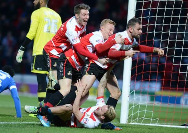 Doncaster players celebrate their second goal.