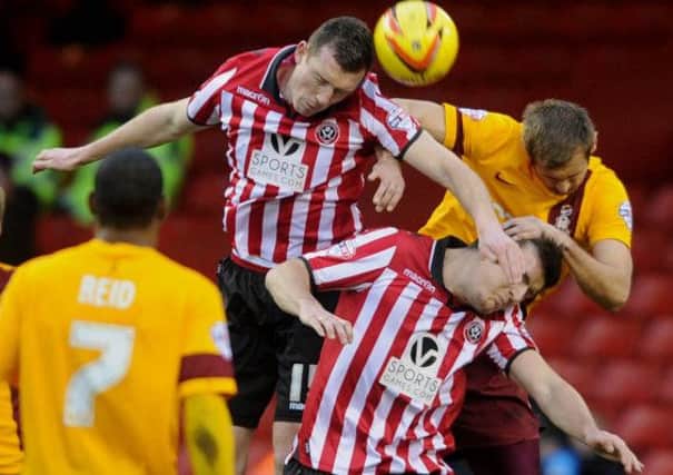 Bradford City's James Hanson, collides with Sheffield United's Neill Collins, and Harry Maguire