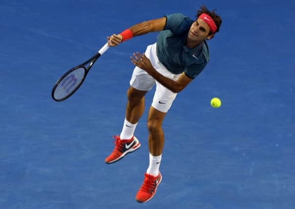 Roger Federer of Switzerland hits a smash to Jo-Wilfried Tsonga of France during their fourth round match
