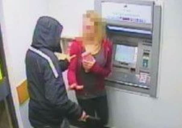 The moment that an 18-year-old girl was confronted by a knife-wielding robber as she withdrew cash from a high street ATM