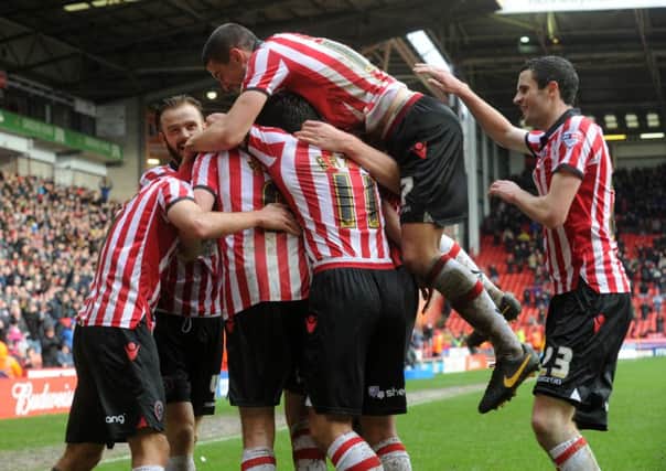 Chris Porter is swamped by team mates as they celebrate his opening goal