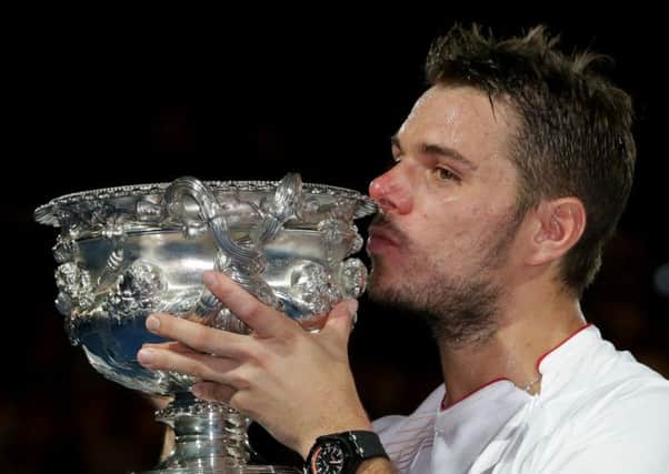 Stanislas Wawrinka of Switzerland kisses the trophy after defeating Rafael Nadal
