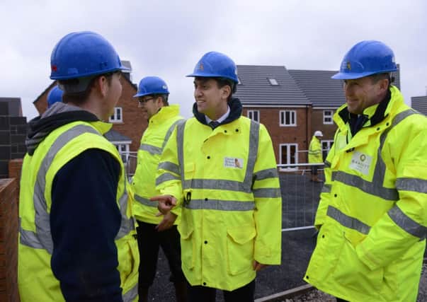 Ed Miliband talks to apprentice Daniel Parnell with Ian Ruthven MD David Wilson Homes during his visit to thier site on Cemetry Road, Pudsey.  31 January 2014.  Picture Bruce Rollinson