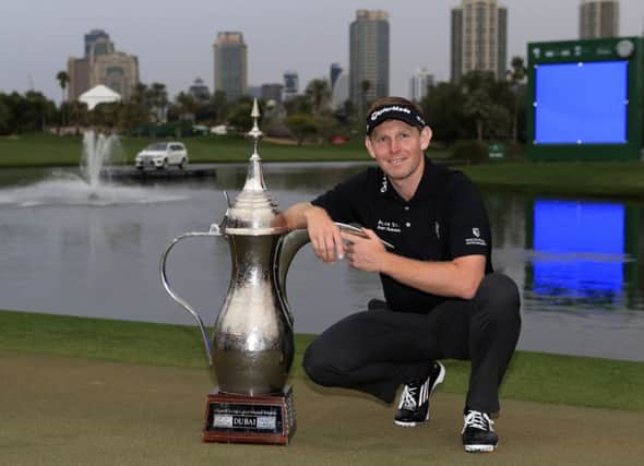 Stephen Gallacher of Scotland poses with the trophy after he wins the final round of the Dubai Desert Classic golf tournament in Dubai, United Arab Emirates