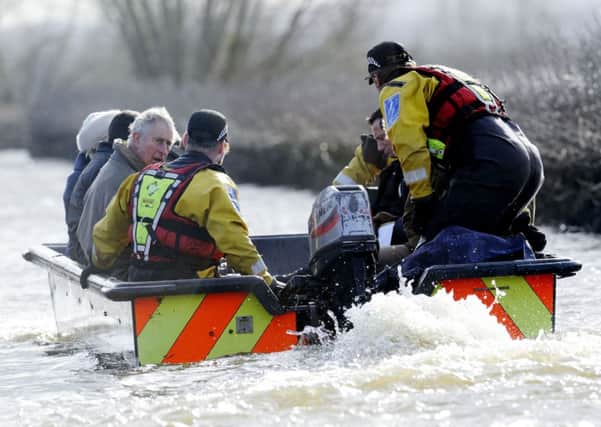 The Prince of Wales uses a small rescue boat to travel to the flood-hit community of Muchleney