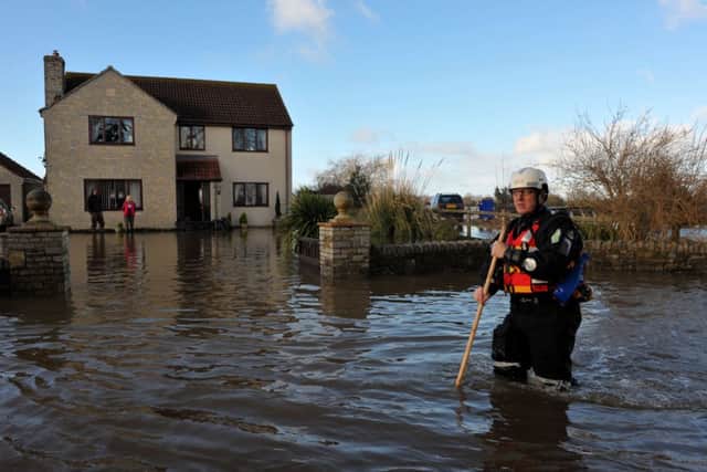 An emergency worker walks down the road outside a property in Moorland, Somerset. Photo: Tim Ireland/PA Wire