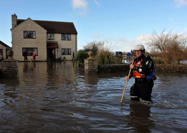 An emergency worker walks down the road outside a property in Moorland, Somerset. Photo: Tim Ireland/PA Wire