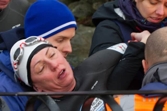 Davina McCall on Day 3 of her Sport Relief Challenge is helped from the water as she completes her swim across Lake Windermere.