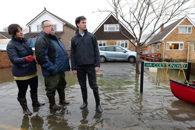 Labour leader Ed Miliband (right) and Victoria Groulef (centre), Labour's Parliamentary Candidate for Reading West, during a visit to the view recent flooding in Purley on Thames in Berkshire.