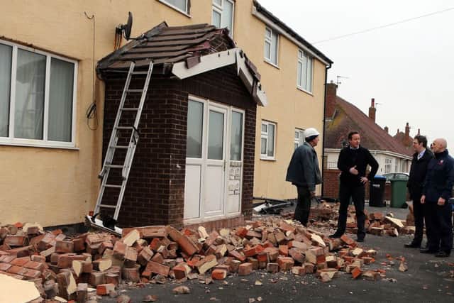Prime Minister David Cameron talks to a builder who is repairing a house that was damaged in the bad weather  in Blackpool