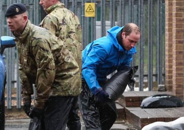 The Duke of Cambridge carrying sandbags in Datchet, Berkshire, as he and his brother, Prince Harry joined colleagues from the armed forces in helping to defend the town from floods
