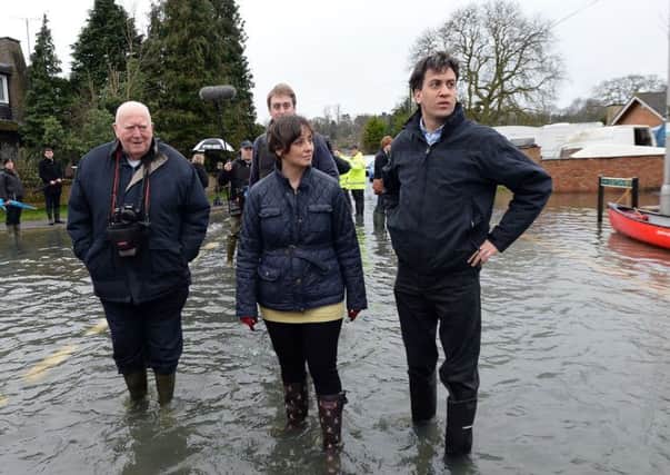 Labour leader Ed Miliband (right) and Victoria Groulef (centre), Labour's Parliamentary Candidate for Reading West, during a visit to the view recent flooding in Purley on Thames in Berkshire.  Photo credit: Andrew Matthews/PA Wire