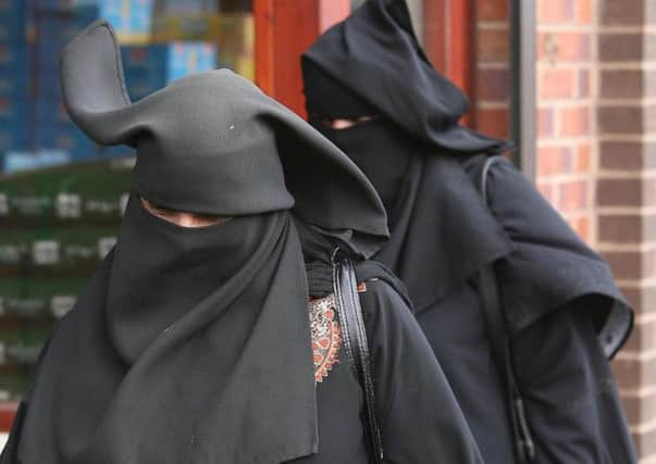 Muslim women out doing their shopping wearing the Niqab.