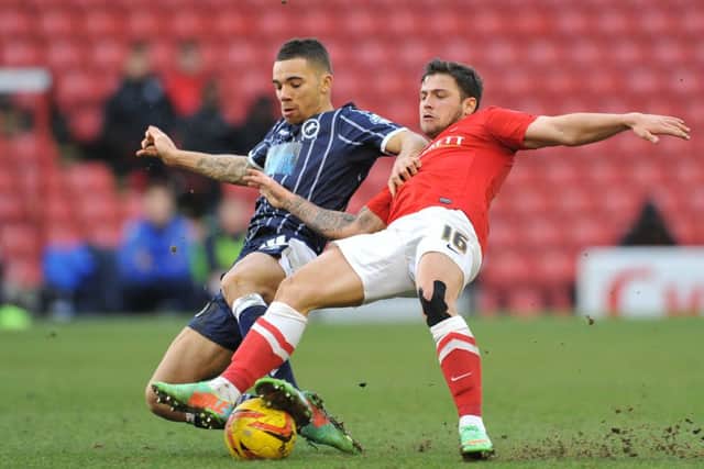 Barnsley's Dale Jennings is pulled back by Millwalls's Ryan Fredericks.