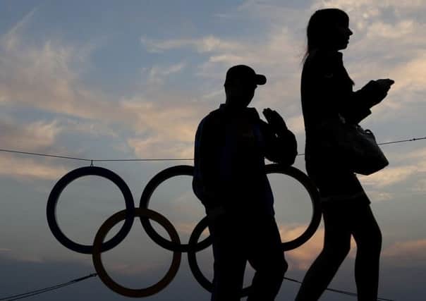 A couple walk past a set of Olympic Rings at a train station overlooking the Black Sea the day after the close of the 2014 Winter Olympics, Monday, Feb. 24, 2014, in Sochi, Russia. (AP Photo/Charlie Riedel)
