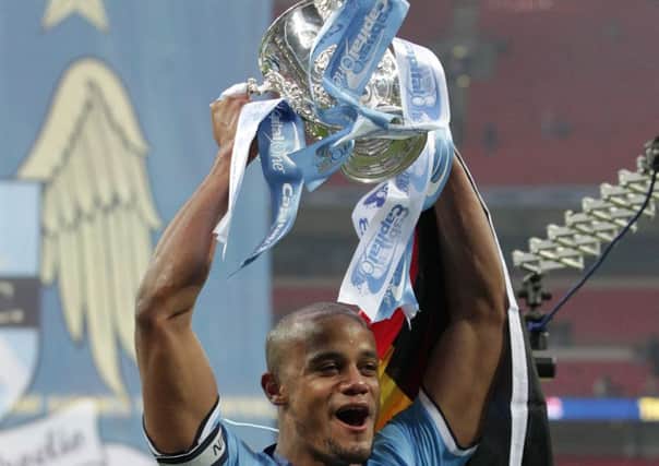 Manchester City captain Vincent Kompany celebrates with the trophy after winning the Capital One Cup Final at Wembley Stadium, London.