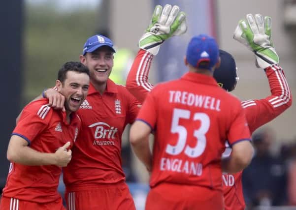 England's Stephen Parry, left, and Stuart Broad, second from left, celebrate with teammates taking the wicket of West Indies' Darren Sammy.