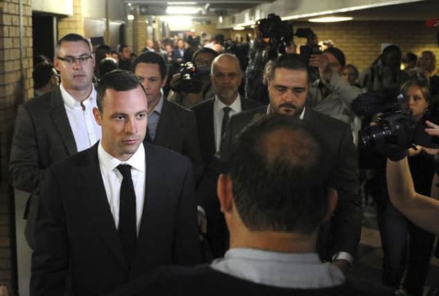 Oscar Pistorius with sister Aimee, aunt Lois, and uncle Arnold (below) wait for the start of his trial