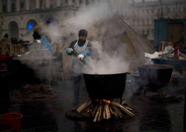 A woman cooks food for anti-Yanukovych protesters at Kiev's Independence Square