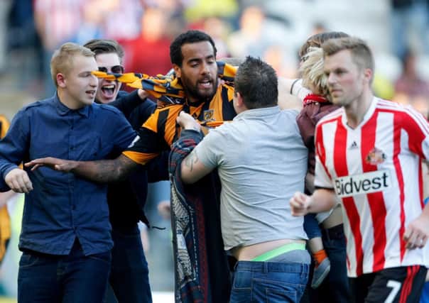 Hull City's Tom Huddlestone battles his way through the pitch invasion after the FA Cup Sixth Round match at the KC Stadium, Hull.