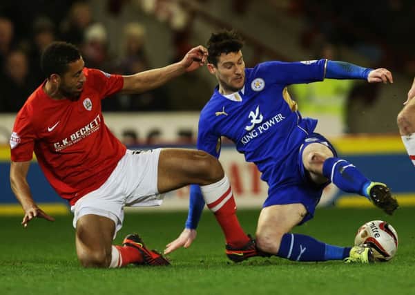 Leicester City's David Nugent and Barnsley's Lewin Nyatanga battle for the ball.