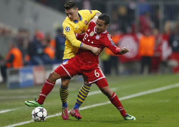 Arsenal's Mesut Ozil battles with Bayern's Thiago Alcantara.