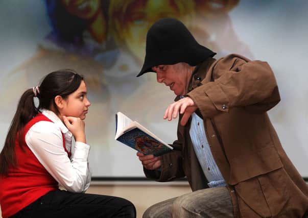 Childrens author Peter Murray reads an extract from his latest book 'Mokee Joe Swamp Warrior' to Simrad Majeed during his visit to Byron Wood Primary School in Sheffield.