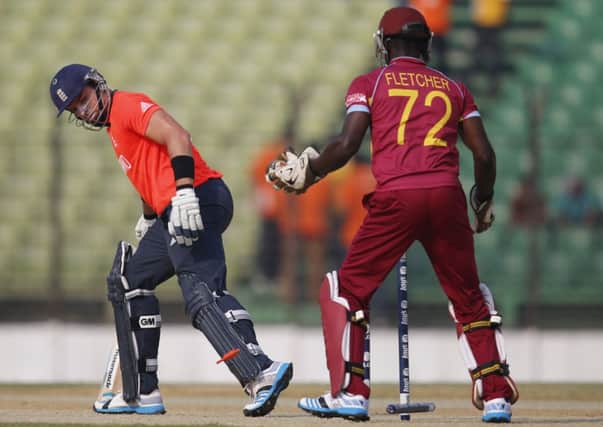 England batsman Michael Lumb, left, looks back at fallen stumps after he was bowled out during their ICC Twenty20 Cricket World Cup warm up match against West Indies. (AP Photo/Aijaz Rahi)