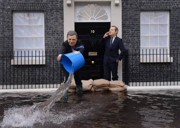 Campaigners dressed as Deputy Prime Minister Nick Clegg (left) and Prime Minister David Cameron pose in front of a mock up of a flooded 10 Downing Street in London, to urge the Prime Minister to act on climate change