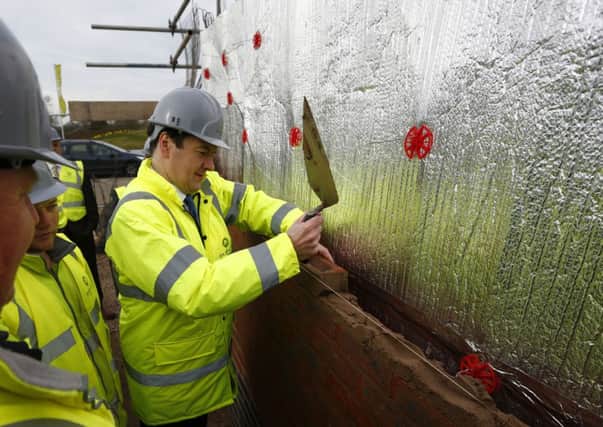 George Osborne lays a brick during a visit to a Barratt Homes building site, the day after he said the government would extend the equity loan portion of the Help to Buy scheme to 2020, a move he said would deliver 120,000 new homes.