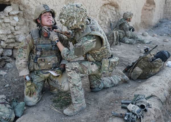 Lance Corporal Simon Moloney receiving medical attention from Lance Corporal Wesley Masters