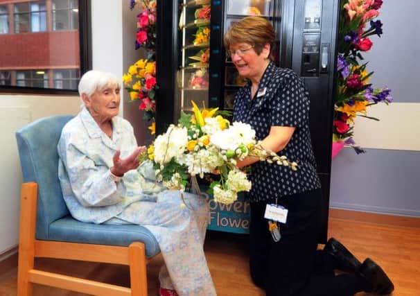 Patient Catherine Vowles recieves silk flowers from Norah Charlesworth, ward clerk on J9, Gledhow Wing at St James' Hospital