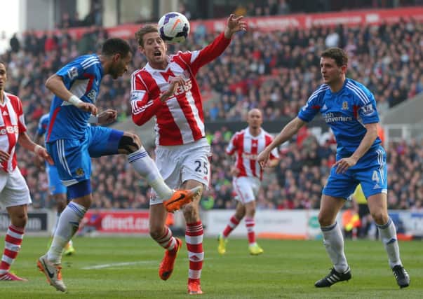 Stoke City's Peter Crouch is kept out by Hull City's Liam Rosenior and Alex Bruce.