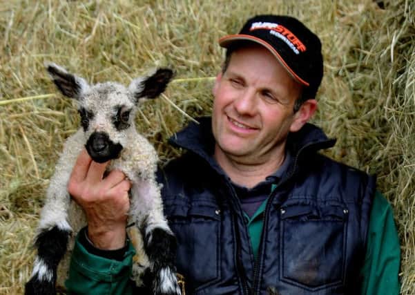 Andrew Fisher with a Teeswater lamb at Wellhouse Farm near Pateley Bridge