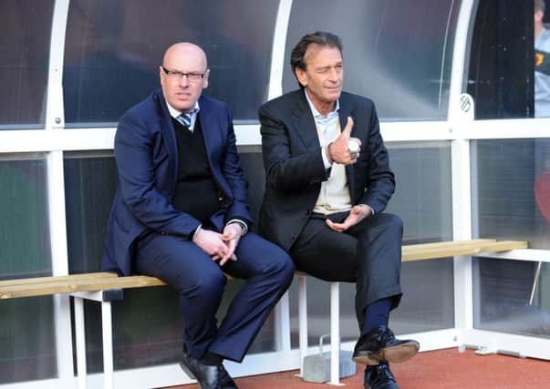 Massimo Cellino sits with Leeds manager Brian McDermott.