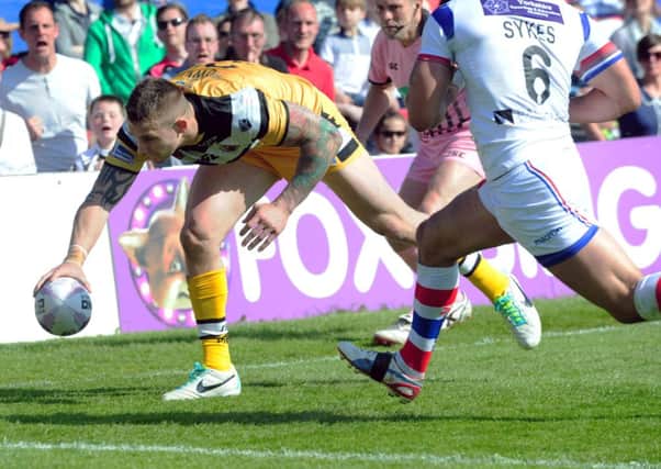 Richard Owen crosses for Castleford as Paul Sykes of Wakefield tries to stop him.