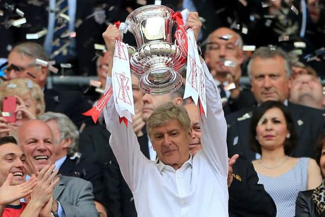Arsenal manager Arsene Wenger celebrates with the FA Cup trophy in the stands after the FA Cup Final at Wembley Stadium, London. PRESS ASSOCIATION Photo. Picture date: Saturday May 17, 2014. See PA Story SOCCER FA Cup. Photo credit should read: Nick Potts/PA Wire. RESTRICTIONS: Use subject to FA restrictions. Editorial use only. Commercial use only with prior written consent of the FA. No editing except cropping. Call +44 (0)1158 447447 or see www.paphotos.com/info/ for full restrictions and further information.