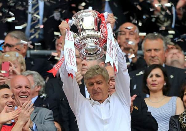 Arsenal manager Arsene Wenger celebrates with the FA Cup trophy in the stands after the FA Cup Final at Wembley Stadium, London. PRESS ASSOCIATION Photo. Picture date: Saturday May 17, 2014. See PA Story SOCCER FA Cup. Photo credit should read: Nick Potts/PA Wire. RESTRICTIONS: Use subject to FA restrictions. Editorial use only. Commercial use only with prior written consent of the FA. No editing except cropping. Call +44 (0)1158 447447 or see www.paphotos.com/info/ for full restrictions and further information.