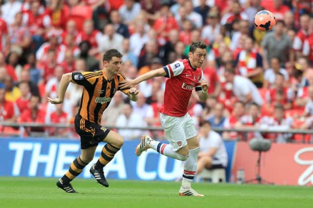 Hull City's Alex Bruce (left) and Arsenal's Mesut Ozil battle for the ball.