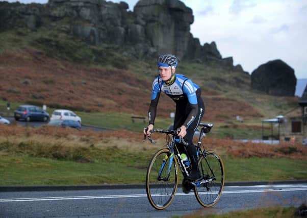 Scott Thwaites, from Burley in Wharfedale, rides past the Cow and Calf Rock above Ilkley.