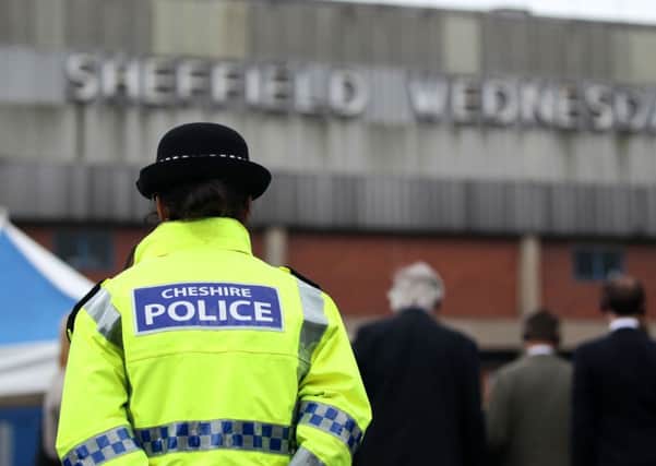 A police officer stands in front of members of the press outside the Hillsborough stadium in Sheffield as jurors on the inquest into the deaths of 96 Liverpool football fans killed in the Hillsborough disaster visited the stadium